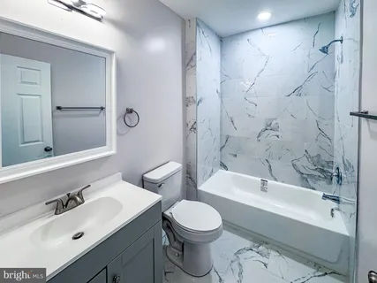 a bathroom with a sink toilet vanity and bathtub