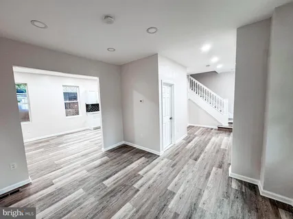 a view of a big room with wooden floor and windows