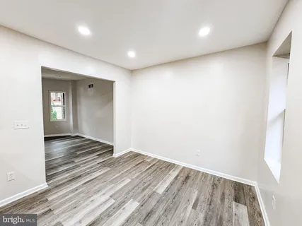 a view of a room with wooden floor and hallway