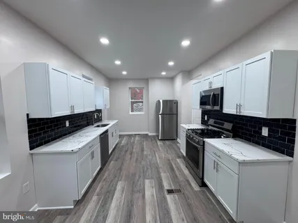 a kitchen with stainless steel appliances a stove a sink and a refrigerator
