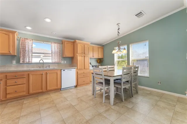 a kitchen with a dining table chairs and white cabinets