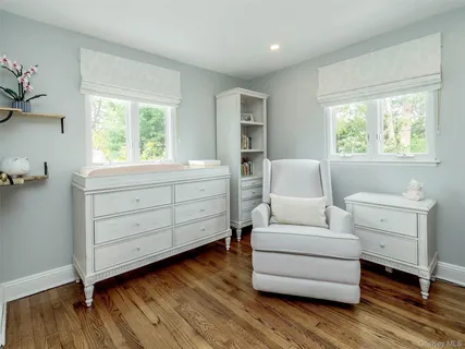 a living room with furniture and two window
