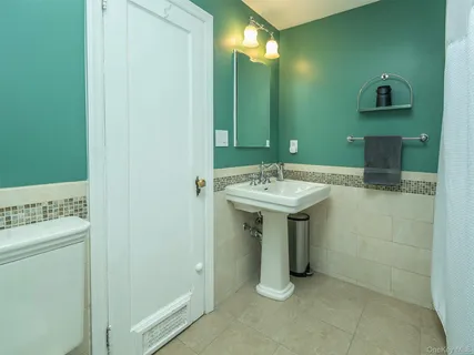 a bathroom with a sink a toilet and mirror