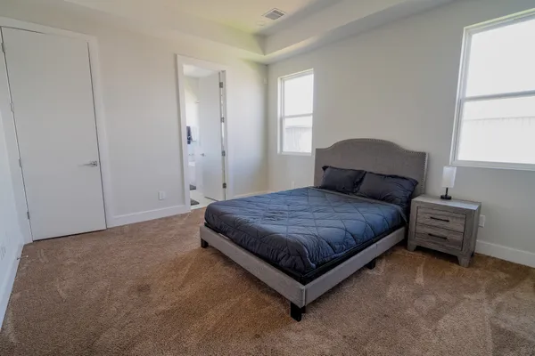 a spacious bedroom with a bed and window