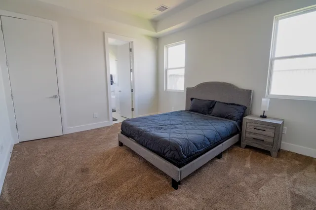 a spacious bedroom with a bed and window