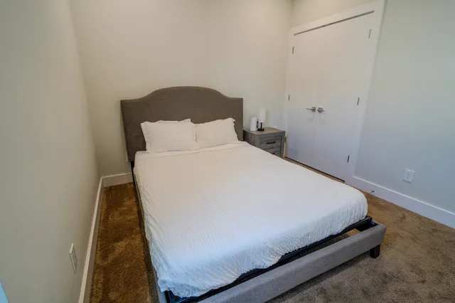 a bed sitting in a bedroom next to a window