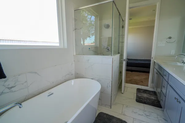 a bathroom with a tub a sink and a shower