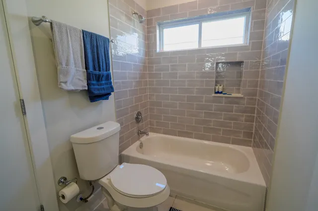 a bathroom with a shower a toilet and bathtub