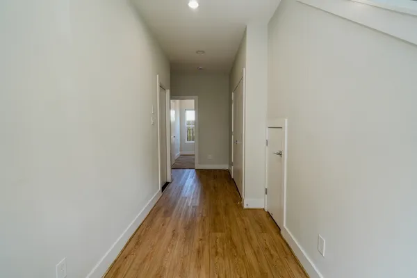 a view of a hallway with wooden floor