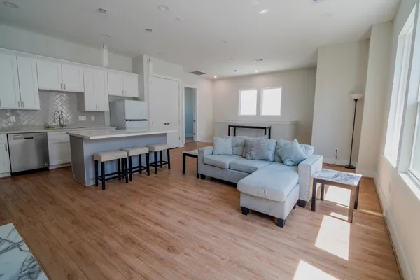 a living room with furniture and a wooden floor