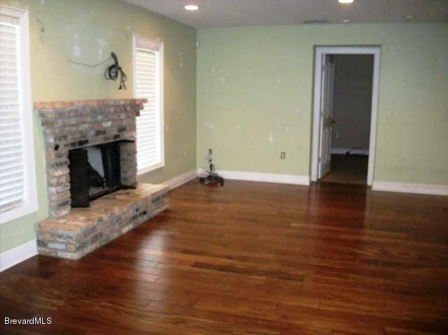 2740 Turtle Mound Road Melbourne, FL 32934 - Photo 2 of 16 a view of a livingroom with wooden floor and a fireplace