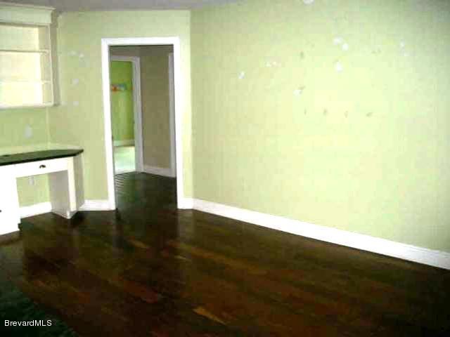 2740 Turtle Mound Road Melbourne, FL 32934 - Photo 4 of 16 a view of an empty room with wooden floor and a window
