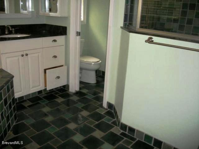 2740 Turtle Mound Road Melbourne, FL 32934 - Photo 9 of 16 a bathroom with a granite countertop sink and a mirror