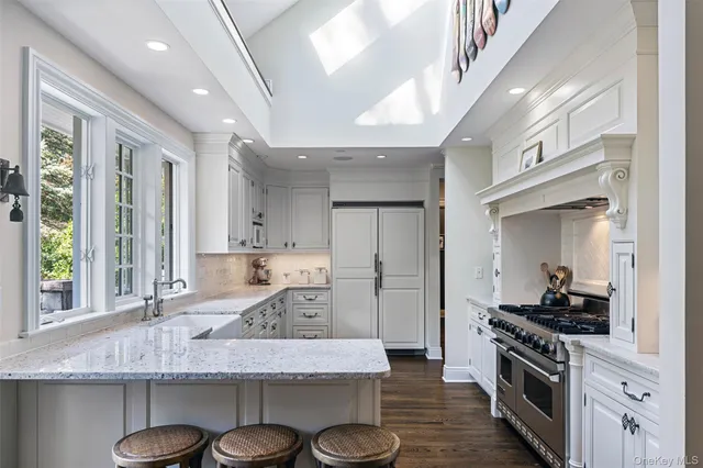 a kitchen with stainless steel appliances granite countertop a sink a stove and a wooden floors