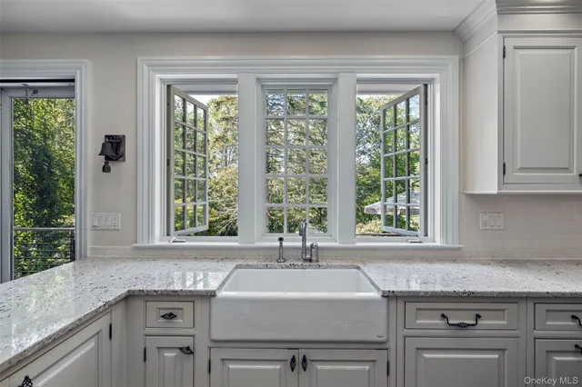 a view with granite countertop a sink and a window