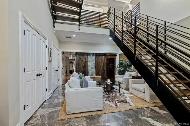 a living room with couches and dining table with wooden floor