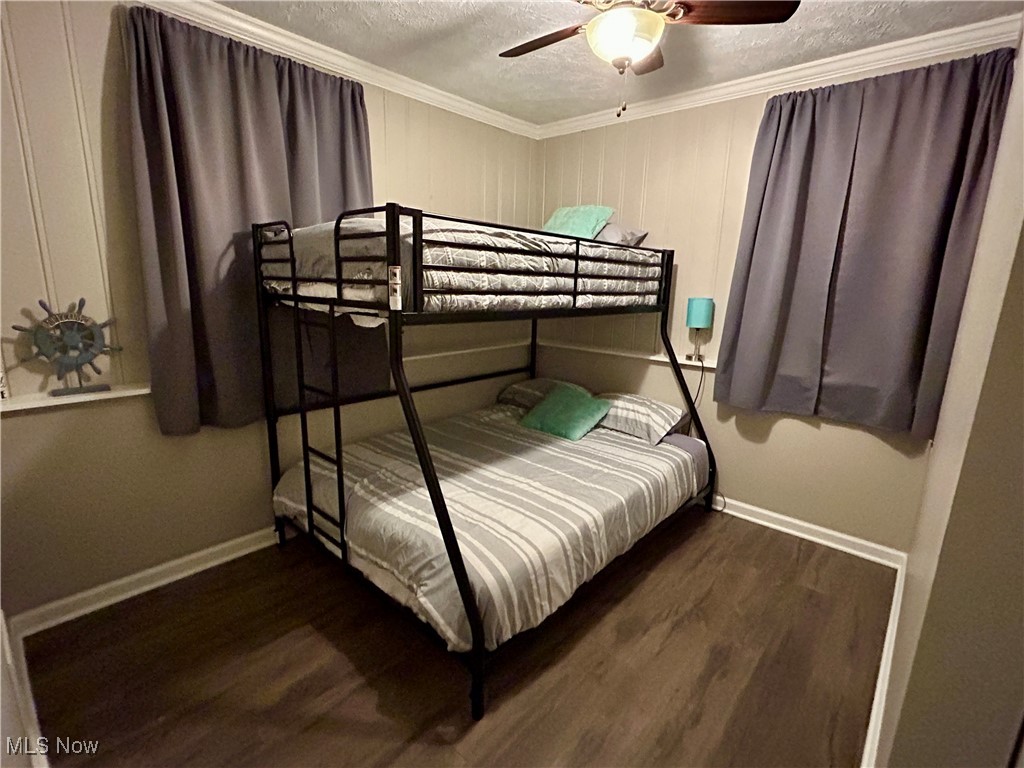 364 Erie Road Vermilion, OH 44089 - Photo 18 of 20 Bedroom with dark wood-type flooring, a textured ceiling, ornamental molding, and ceiling fan