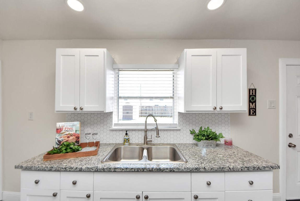 119 Burke Road Pasadena, TX 77506 - Photo 17 of 47 a kitchen with granite countertop white cabinets and window