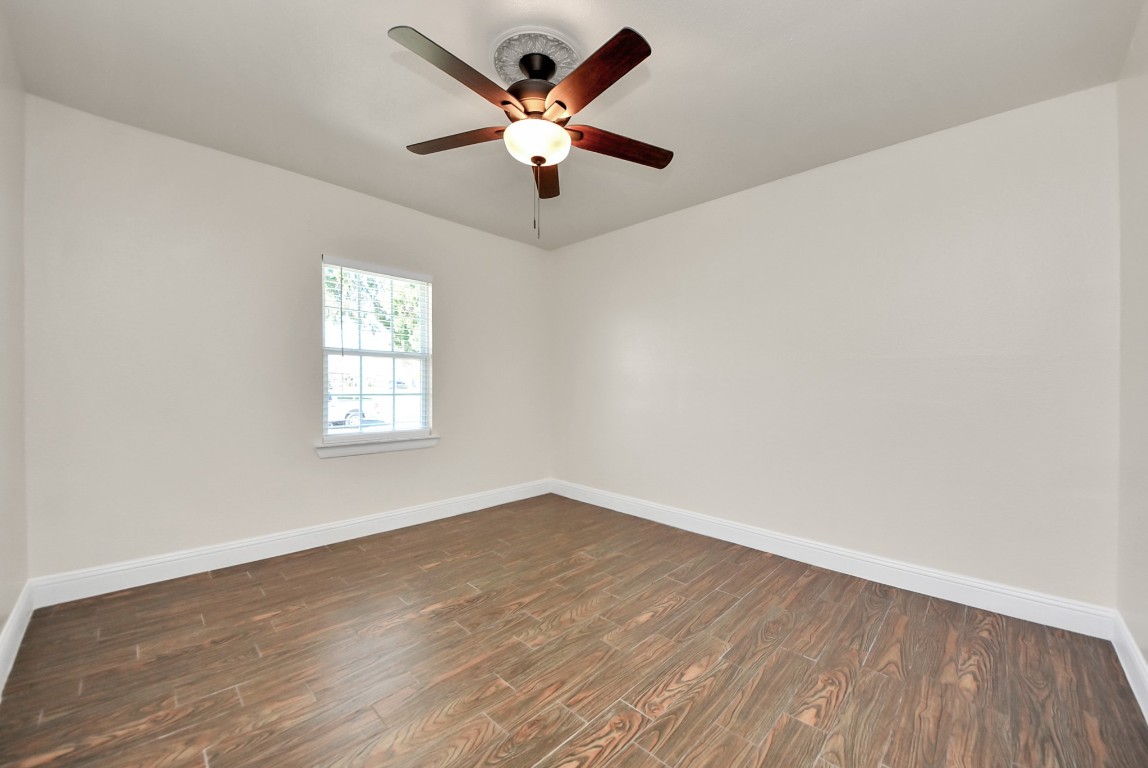 119 Burke Road Pasadena, TX 77506 - Photo 23 of 47 an empty room with wooden floor ceiling fan and windows