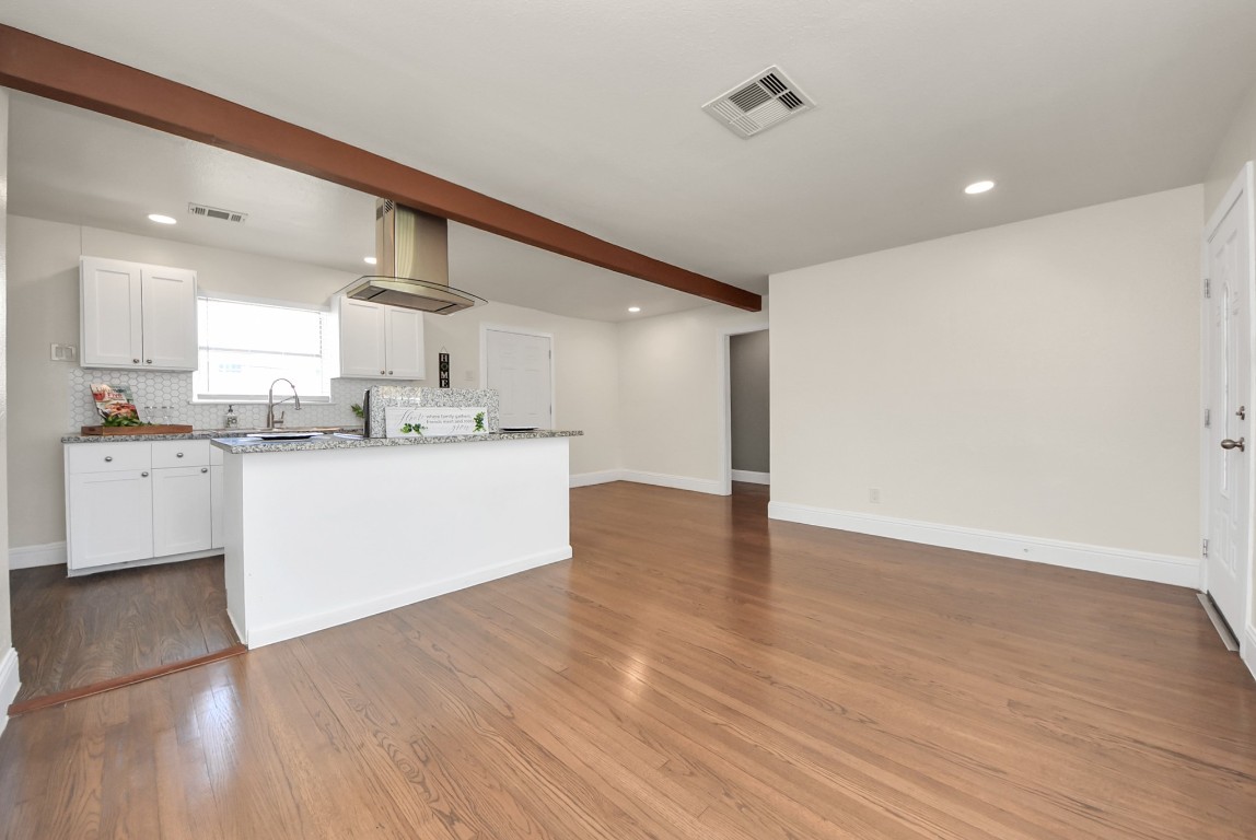119 Burke Road Pasadena, TX 77506 - Photo 6 of 47 a large white kitchen with wooden floors and white walls