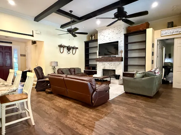 a view of a hallway with wooden floor and a bookshelf