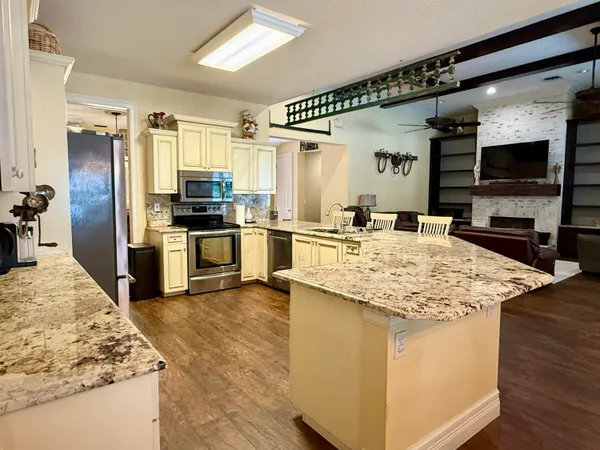 a bathroom with a granite countertop sink a toilet and a mirror