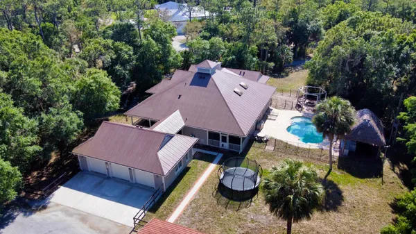 an aerial view of a house with a yard and swimming pool