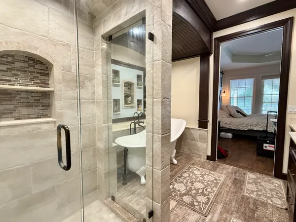 a view of a house with a yard plants and large tree