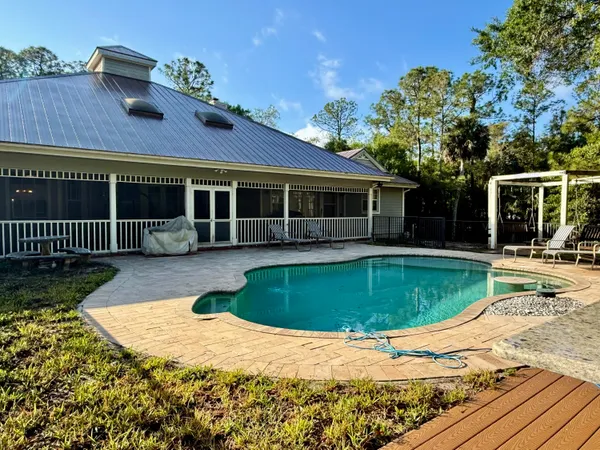 an aerial view of residential house with outdoor space and trees all around