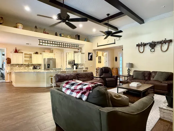 a living room with furniture a flat screen tv and kitchen view