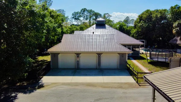 a view of swimming pool with a big yard and large trees