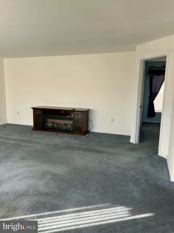 a view of an empty room with closet and a window