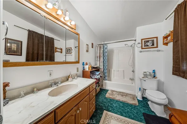a bathroom with a granite countertop sink mirror vanity and toilet