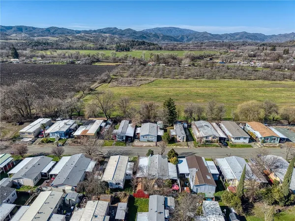 an aerial view of a city with lots of residential buildings and mountain view in back