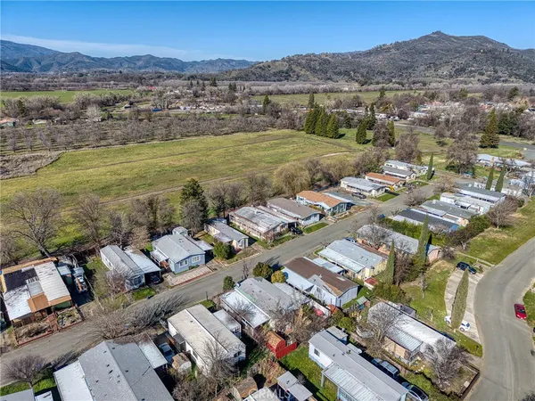 an aerial view of a city with lots of residential buildings and mountain view in back