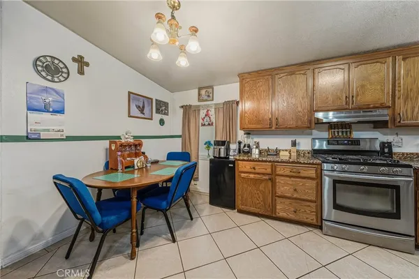 a kitchen with stainless steel appliances kitchen island granite countertop a sink a stove a dining table and chairs