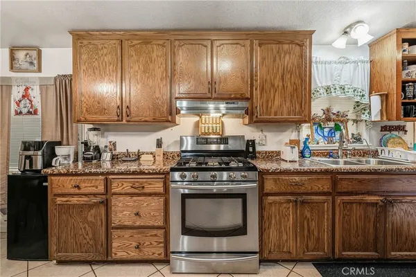 a kitchen with granite countertop wooden cabinets and stainless steel appliances