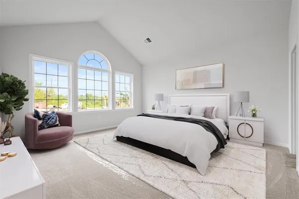a bedroom with a large bed and a couch