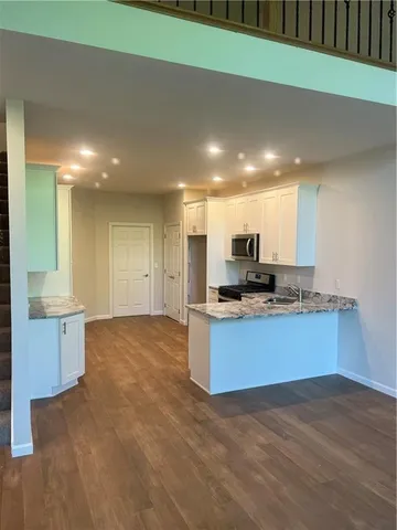 a large kitchen with kitchen island a sink stainless steel appliances and cabinets