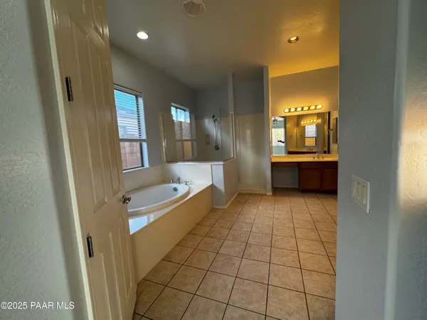 a bathroom with a tub shower and sink