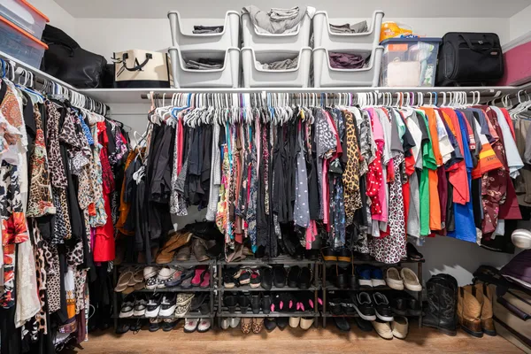 a view of walk in closet with clothes and shoes