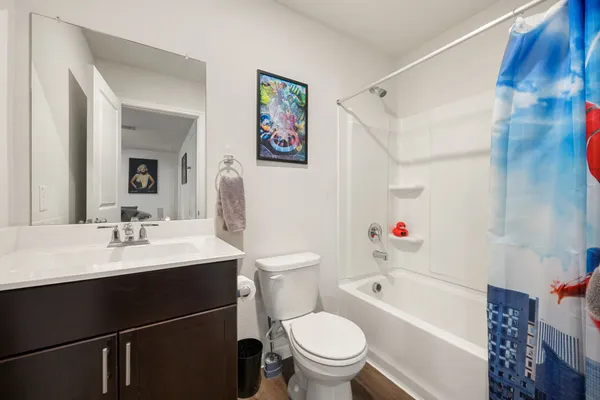 a bathroom with a sink toilet vanity and tub