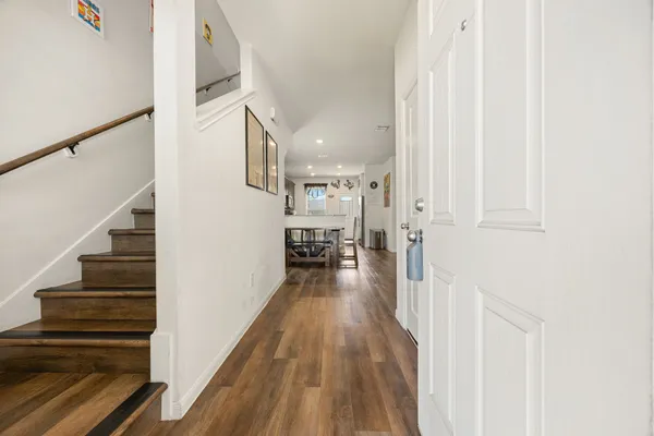 a view of a hallway with wooden floor and staircase