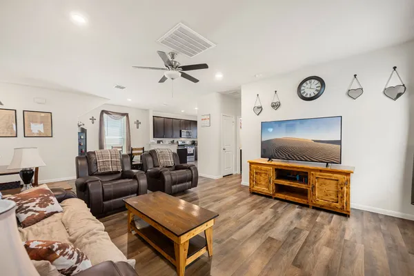 a living room with furniture a flat screen tv and a window