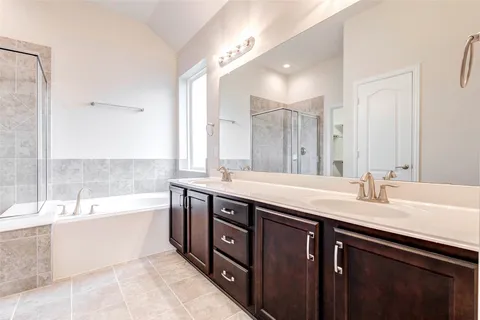 a spacious bathroom with a tub sink and mirror