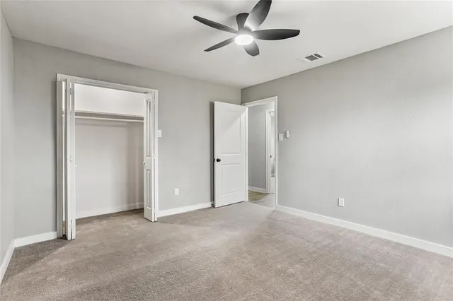 a view of an empty room and a ceiling fan