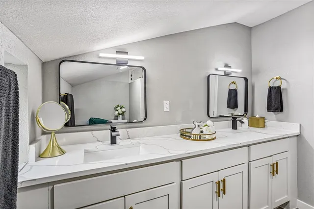a bathroom with double vanity sinks and a mirror