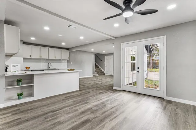 a view of kitchen with cabinets stainless steel appliances and wooden floor