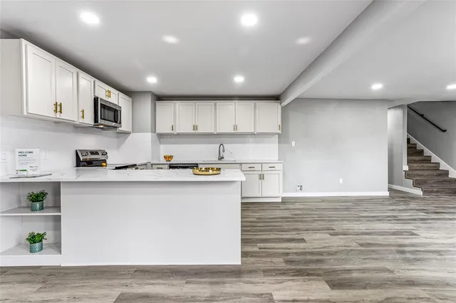 a kitchen with stainless steel appliances granite countertop a stove a sink and a refrigerator