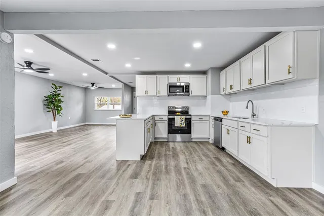 a kitchen with granite countertop a stove top oven sink and cabinets